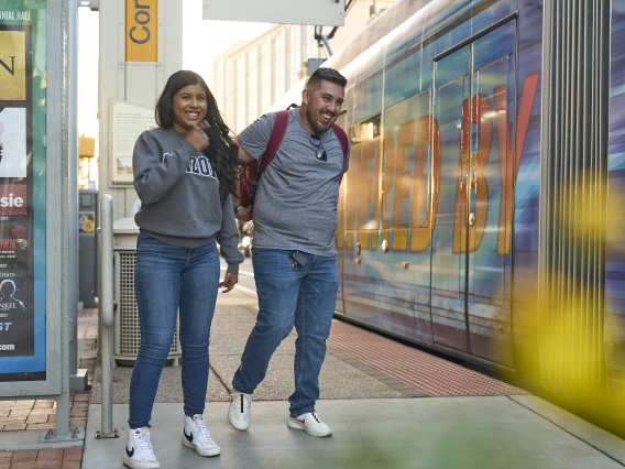 he University of Arizona Downtown Tram Stop, a modern transit station serving the downtown area, is shown on a sunny day.