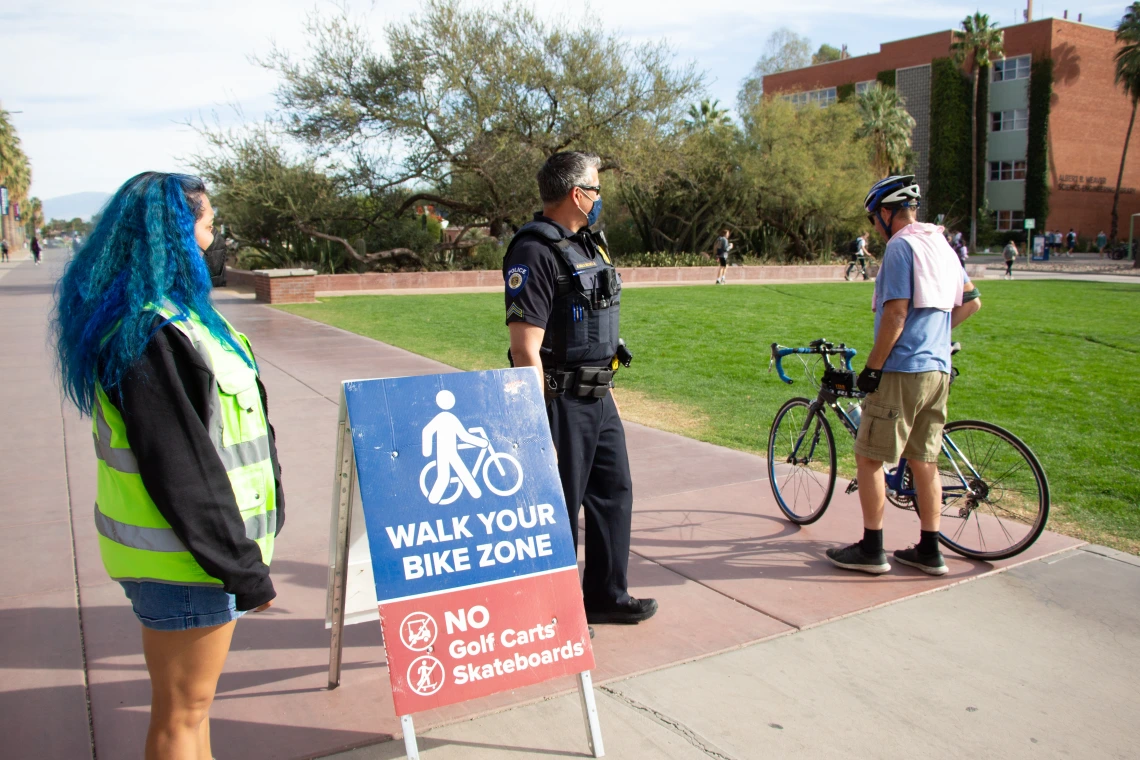 Image of student walking bike at UA Mall