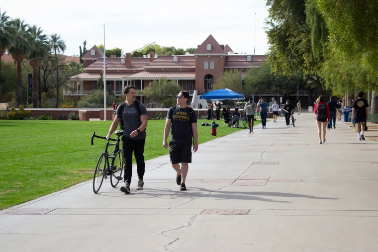 Image of student walking bike at UA Mall